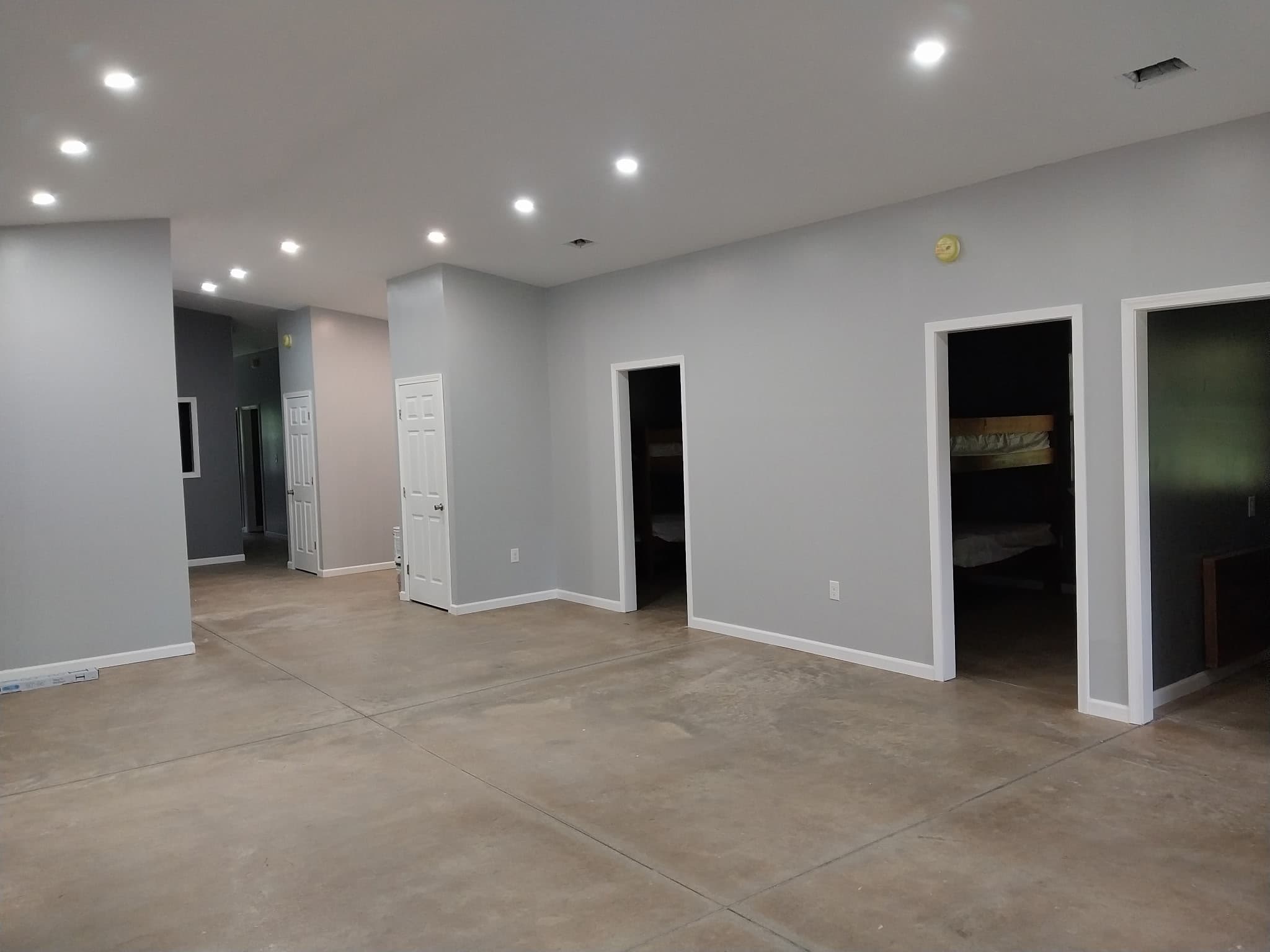 Gray-walled gathering space with doorways to bunk rooms