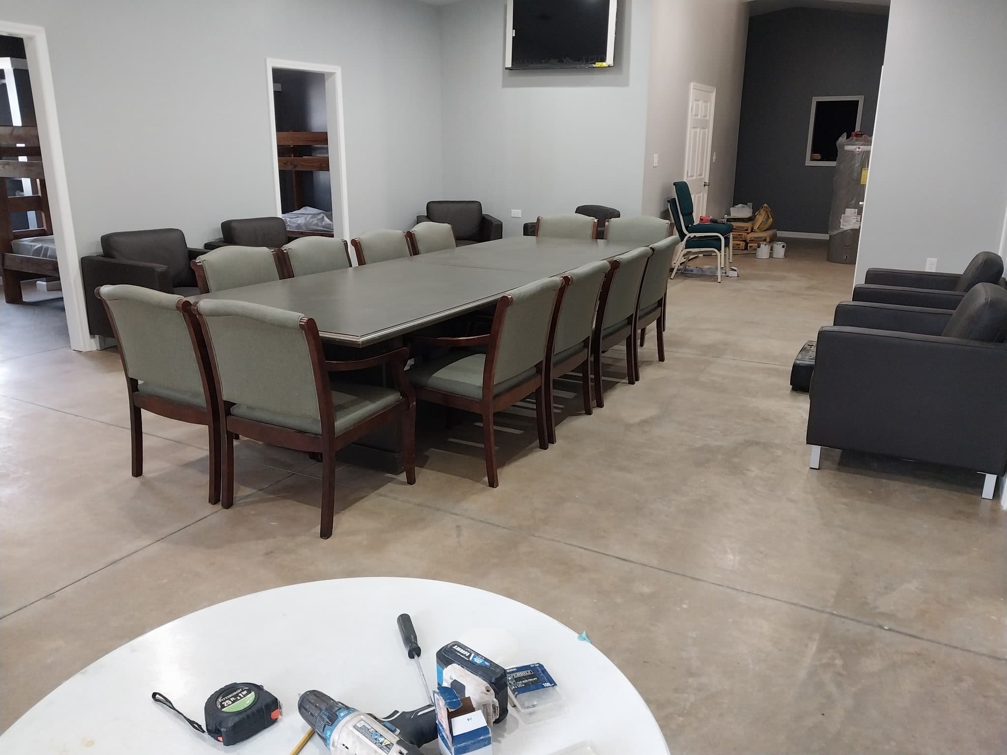Dining hall with long table and lounge seating at Camp Legacy